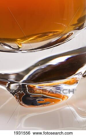 close-up of the base of a glass filled with an orange liquid View Large Photo Image Stock Photograph - close-up of the base of a glass filled with an orange liquid. Fotosearch