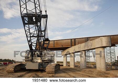 Stock Image - crane beside new bridge construction; st. albert, alberta, canada. Fotosearch