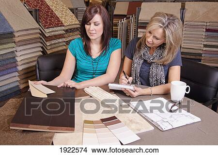 Picture - design consultant assisting a customer in a retail flooring store; edmonton, alberta, canada. Fotosearch