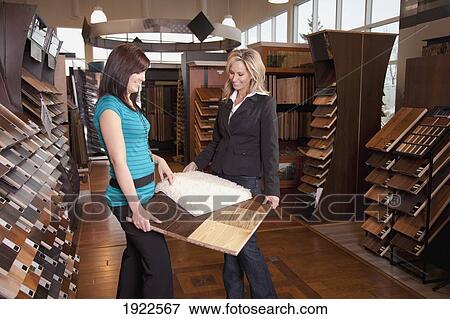 Stock Photo - design consultant assisting a customer in a retail flooring store; edmonton, alberta, canada. Fotosearch