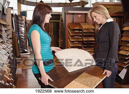 Stock Photo - design consultant assisting a customer in a retail flooring store; edmonton, alberta, canada. Fotosearch
