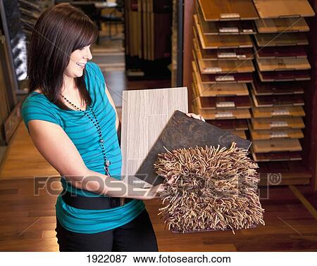 Stock Photo - design consultant showing samples in a retail flooring store; edmonton, alberta, canada. Fotosearch