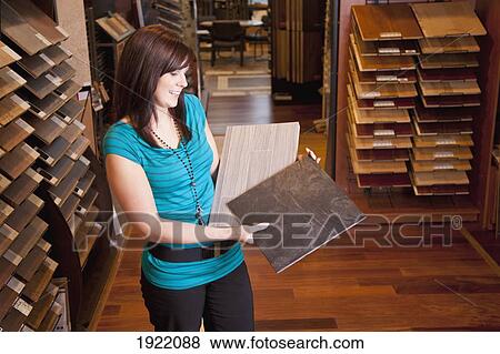 Stock Photo - design consultant showing samples in a retail flooring store; edmonton, alberta, canada. Fotosearch