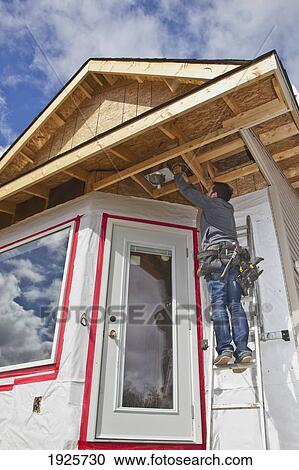 Stock Image - electrician installing light fixtures; edmonton, alberta, canada. Fotosearch