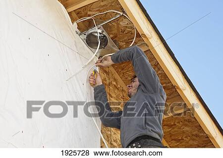 Stock Photo - electrician installing light fixtures on house. Fotosearch