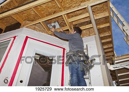 electrician installing light fixtures; edmonton, alberta, canada View Large Photo Image Stock Photo - electrician installing light fixtures; edmonton, alberta, canada. Fotosearch