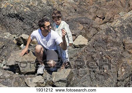 Stock Image - father and son exploring shoreline along bc coast; british columbia, canada. Fotosearch