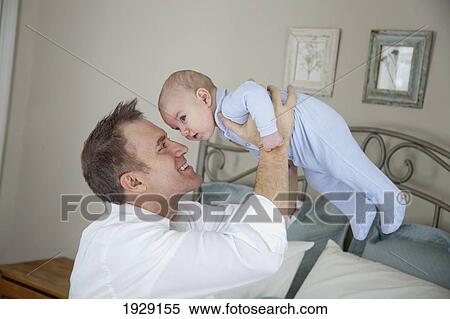 Stock Photography - father playing with baby. Fotosearch