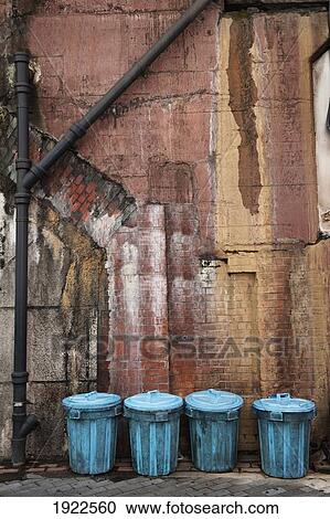 Stock Image - four garbage cans in a row against a dirty wall in an alley; tokyo, japan. Fotosearch