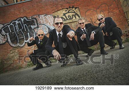 four groomsmen wearing sunglasses in front of a graffiti wall View Large Photo Image Stock Photo - four groomsmen wearing sunglasses in front of a graffiti wall. Fotosearch
