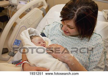 Stock Image - mother holding newborn baby daughter. Fotosearch