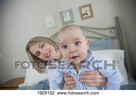 Stock Image - mother holding up baby. Fotosearch