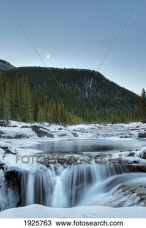 Stock Image - partially frozen waterfall in the canadian rockies; bragg creek, alberta, canada. Fotosearch