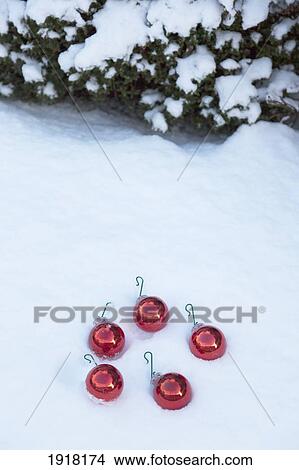 red christmas ornaments in the snow; whitburn, tyne and wear, england View Large Photo Image Picture - red christmas ornaments in the snow; whitburn, tyne and wear, england. Fotosearch