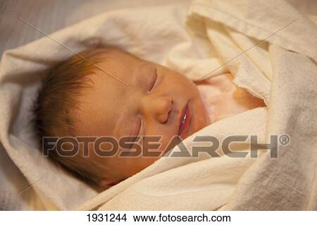 Picture - sleeping baby wrapped in a white blanket; edmonton, alberta, canada. Fotosearch
