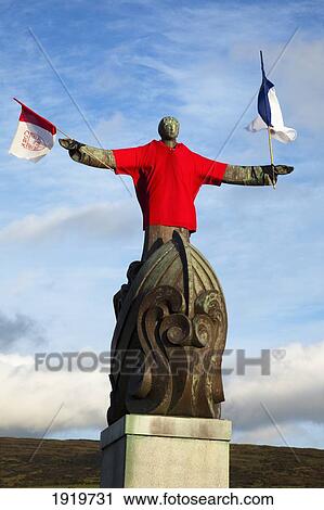 Stock Image - Statue Wearing Soccer Jersey And Holding Flags; Bantry, County Cork, Ireland. Fotosearch