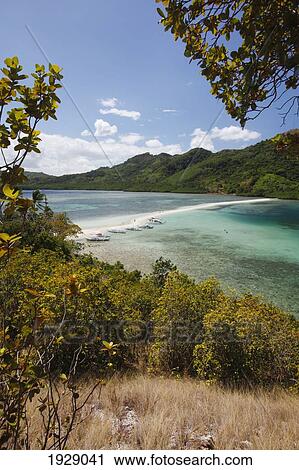 Stock Image - the pure white sands of snake island and bangka boats on the shore, near el nido; bacuit archipelago, palawan, philippines. Fotosearch