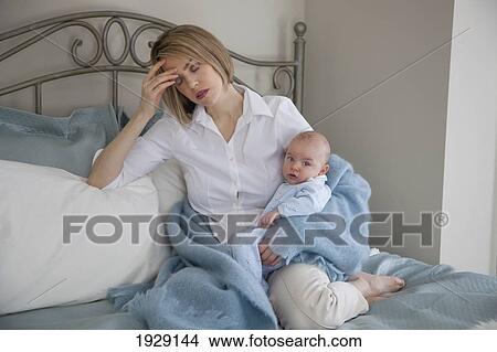 Picture - tired mom in bed with a baby; jordan, ontario, canada. Fotosearch
