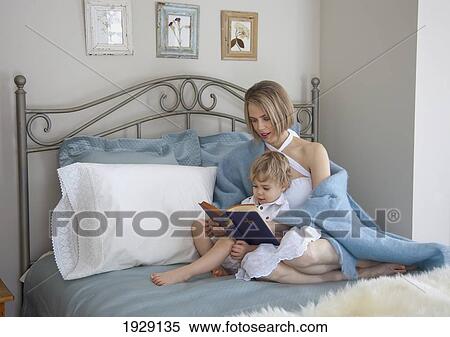 Stock Photography - toddler and mother in bed reading; jordan, ontario, canada. Fotosearch