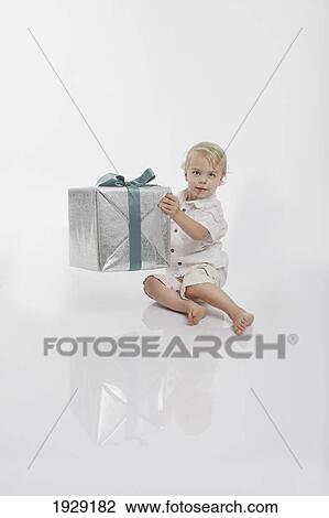toddler holding a wrapped gift View Large Photo Image Stock Image - toddler holding a wrapped gift. Fotosearch