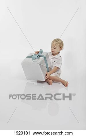toddler looking at a wrapped gift View Large Photo Image Stock Image - toddler looking at a wrapped gift. Fotosearch