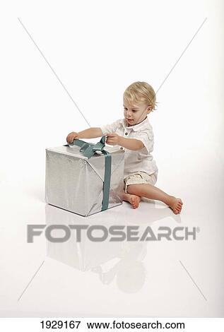 toddler unwrapping gift against white background View Large Photo Image Stock Photo - toddler unwrapping gift against white background. Fotosearch