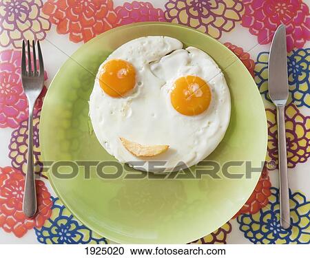 Stock Image - two eggs making a happy face on a plate. Fotosearch