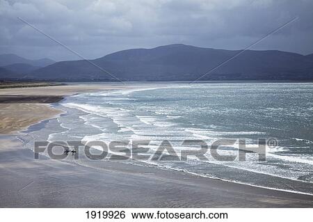 Two People Walking With Surfboards On The Beach In Inch On The Dingle Peninsula; County Kerry, Ireland View Large Photo Image Stock Photograph - Two People Walking With Surfboards On The Beach In Inch On The Dingle Peninsula; County Kerry, Ireland. Fotosearch