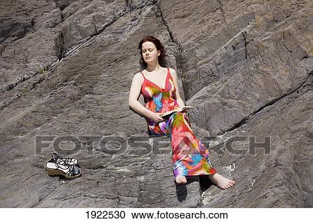 woman relaxing on rock at beach; derrynane beach, county kerry, ireland View Large Photo Image Stock Image - woman relaxing on rock at beach; derrynane beach, county kerry, ireland. Fotosearch