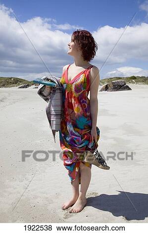 Stock Photo - woman standing on beach; derrynane beach, county kerry, ireland. Fotosearch