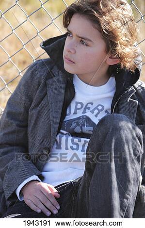 A Boy Sitting Against A Chain-Link Fence; Troutdale Oregon United States Of America View Large Photo Image Stock Image - A Boy Sitting Against A Chain-Link Fence; Troutdale Oregon United States Of America. Fotosearch