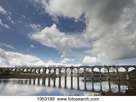 Stock Photo - a bridge reflected in the water; berwick northumberland england. Fotosearch