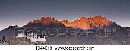 Stock Photo - A Building On A Rock Ledge With Alpenglow Over The Mountains In The Background; Lamayuru Ladakh India. Fotosearch