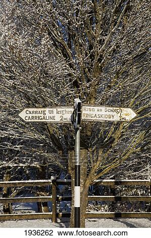 Stock Image - A Distance Sign Posted In Winter Near Carrigaline; County Cork Ireland. Fotosearch