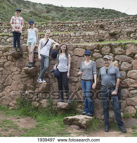 Stock Photo - A Family Stands Posing On Rocks At The Incan Ruins; Moray Peru. Fotosearch