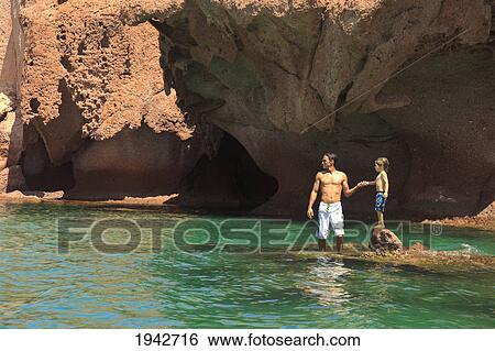 A Father And Son Standing On A Rock In The Ocean At Los Islotes National Marine Park Espiritu Santo Island; La Paz Baja California Mexico View Large Photo Image Stock Photograph - A Father And Son Standing On A Rock In The Ocean At Los Islotes National Marine Park Espiritu Santo Island; La Paz Baja California Mexico. Fotosearch