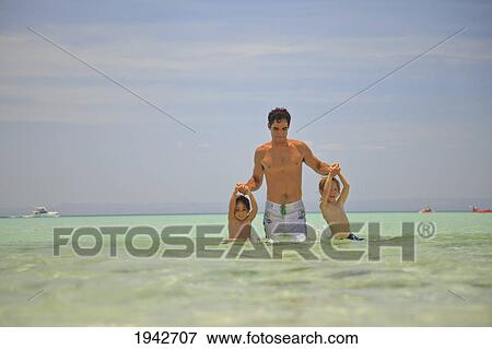 Stock Photo - A Father Plays With His Sons In The Ocean At Los Islotes National Marine Park Espiritu Santo Island; La Paz Baja California Mexico. Fotosearch