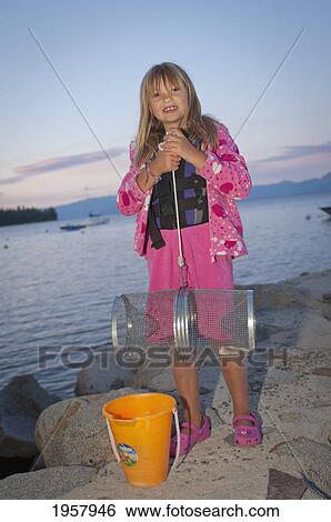 a girl holding a fishing trap at the lake on meeks bay at sunset; lake tahoe california united states of america View Large Photo Image Stock Photograph - a girl holding a fishing trap at the lake on meeks bay at sunset; lake tahoe california united states of america. Fotosearch