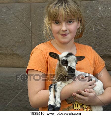 Stock Image - A Girl Holding A Lamb; Cusco Peru. Fotosearch