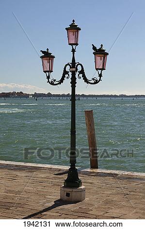 Stock Image - A Lampstand On The Promenade Along The Water; Venice Italy. Fotosearch