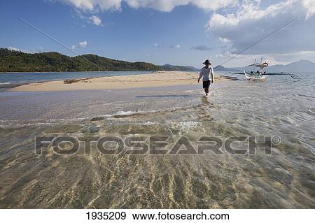 A Male Tourist Walks Along The White Sand On A Small Island Near El Nido; Bacuit Archipelago, Palawan, Philippines View Large Photo Image Stock Photo - A Male Tourist Walks Along The White Sand On A Small Island Near El Nido; Bacuit Archipelago, Palawan, Philippines. Fotosearch