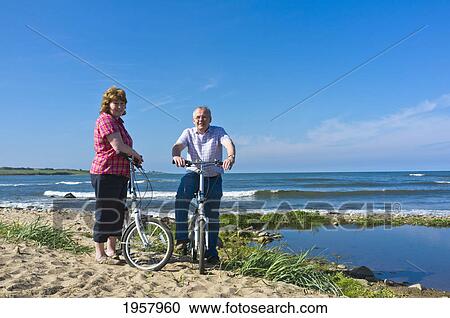 a man and woman with their bicycles on the beach; northumberland england View Large Photo Image Stock Image - a man and woman with their bicycles on the beach; northumberland england. Fotosearch