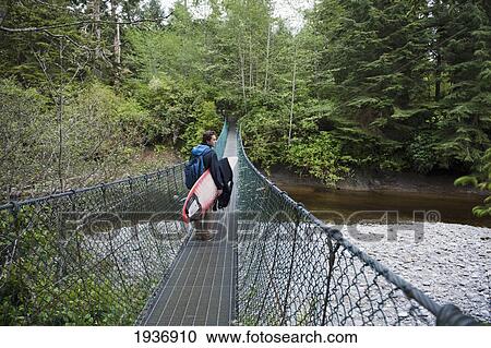 A Man Carries His Surfboard Over A Bridge At China Beach; British Columbia Canada View Large Photo Image Stock Image - A Man Carries His Surfboard Over A Bridge At China Beach; British Columbia Canada. Fotosearch