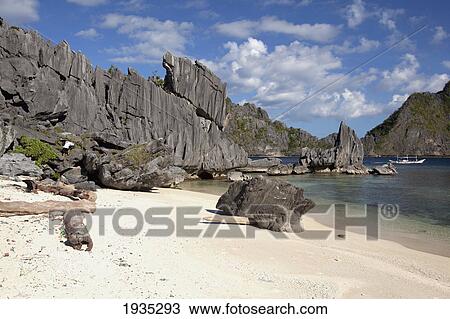 Stock Image - A Man Climbs Limestone Rock Formations; Tapiutan Island, Palawan, Philippines. Fotosearch