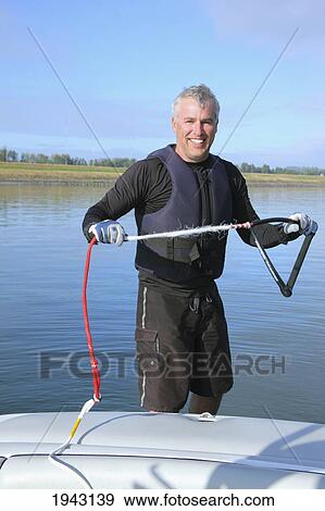 Stock Photo - A Man Holding A Water Skiing Rope In His Hands At The Back Of A Boat; Troutdale Oregon United States Of America. Fotosearch