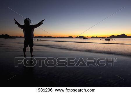 A Man On A Beach At Sunset; Corong-Corong, Palawan, Philippines View Large Photo Image Stock Photograph - A Man On A Beach At Sunset; Corong-Corong, Palawan, Philippines. Fotosearch