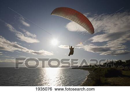 Stock Photograph - A Man Paragliding Along The Cliffs At Dallas Road; Victoria, Vancouver Island, British Columbia, Canada. Fotosearch