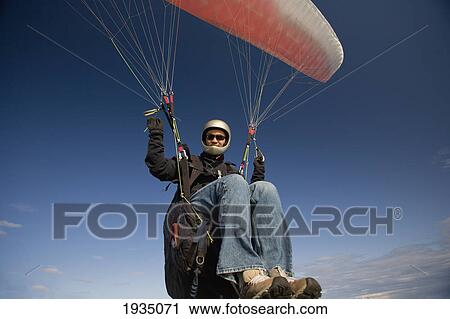Stock Image - A Man Paragliding; Victoria, Vancouver Island, British Columbia, Canada. Fotosearch