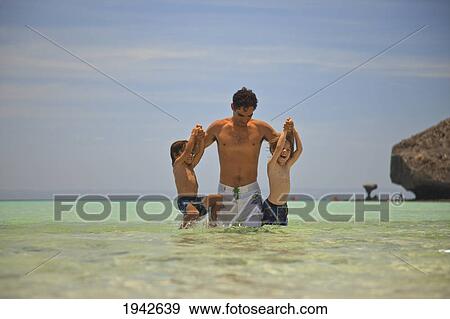 A Man Plays In The Water With Two Boys At Los Islotes National Marine Park Espiritu Santos Island; La Paz Baja California Mexico View Large Photo Image Stock Photo - A Man Plays In The Water With Two Boys At Los Islotes National Marine Park Espiritu Santos Island; La Paz Baja California Mexico. Fotosearch