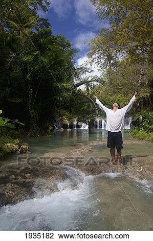 A Man Raises His Arms In Praise At Tranquil Waterfall; Cambugahay Falls, Siquijor, Philippines View Large Photo Image Stock Image - A Man Raises His Arms In Praise At Tranquil Waterfall; Cambugahay Falls, Siquijor, Philippines. Fotosearch